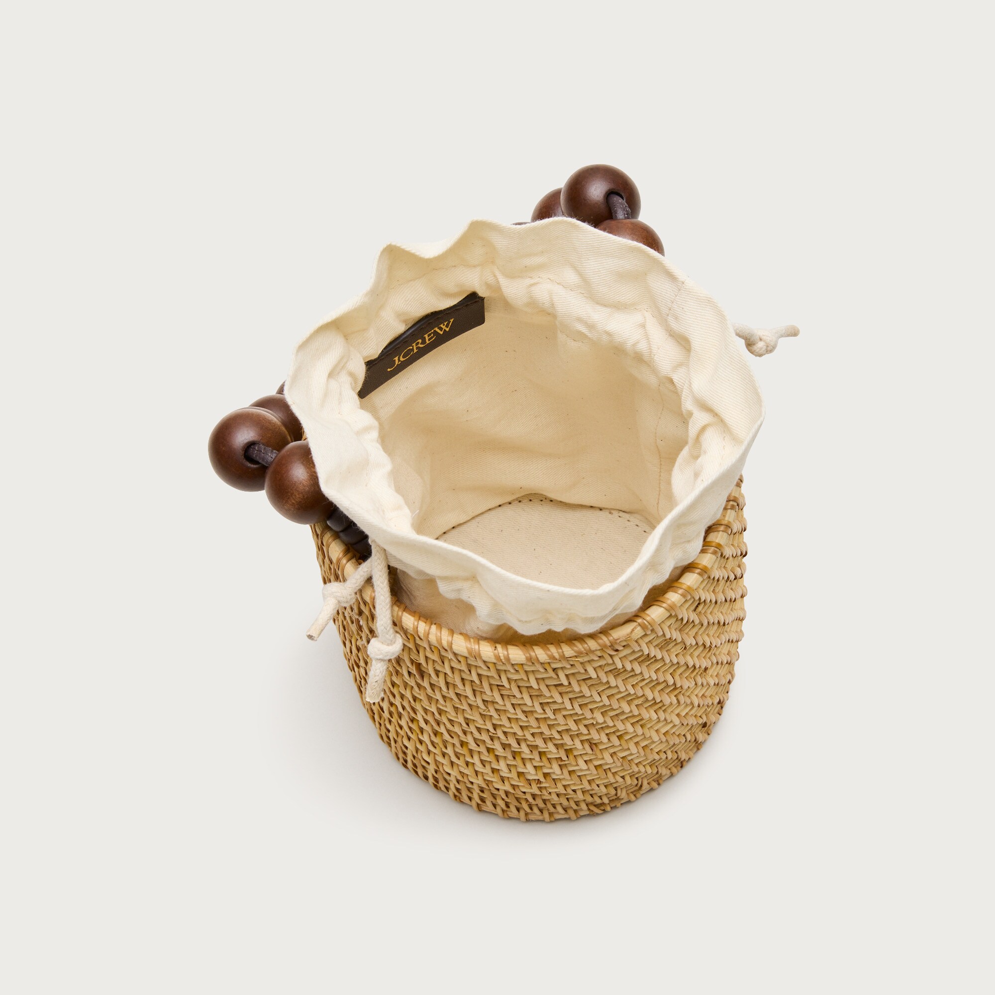 Handknotted rattan bucket bag with wood beads